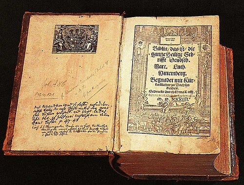 The 1534 title page of Luther's German Bible. A large woodcut frames the title text, with intertwining vines, angels, and biblical scenes around the borders. The text in old German Gothic script reads 'Biblia / das ist / die / gantze Heilige / Schrifft Deudsch' — Bible, that is, the entire Holy Scripture in German.
