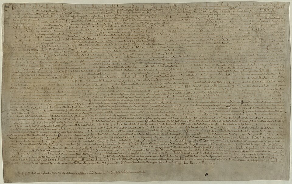 A weathered medieval parchment of Magna Carta from 1215, in dense Latin handwriting, with a damaged wax seal.