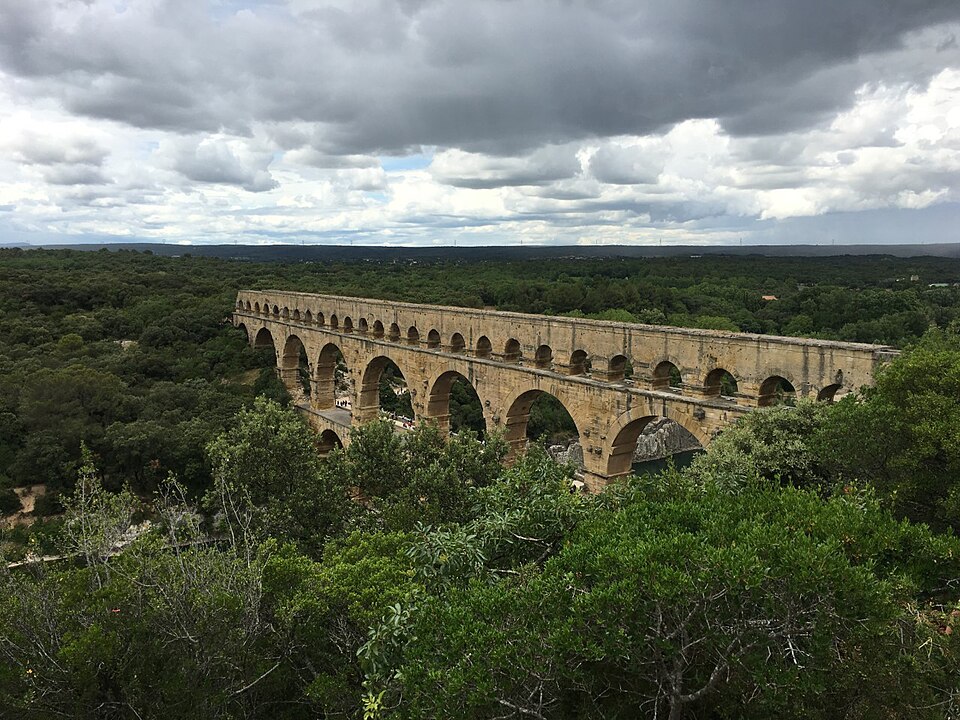 The Pont du Gard, a massive three-tiered Roman aqueduct bridge of golden stone arches spanning a river valley in southern France, built in the first century AD to carry water to the city of N&icirc;mes